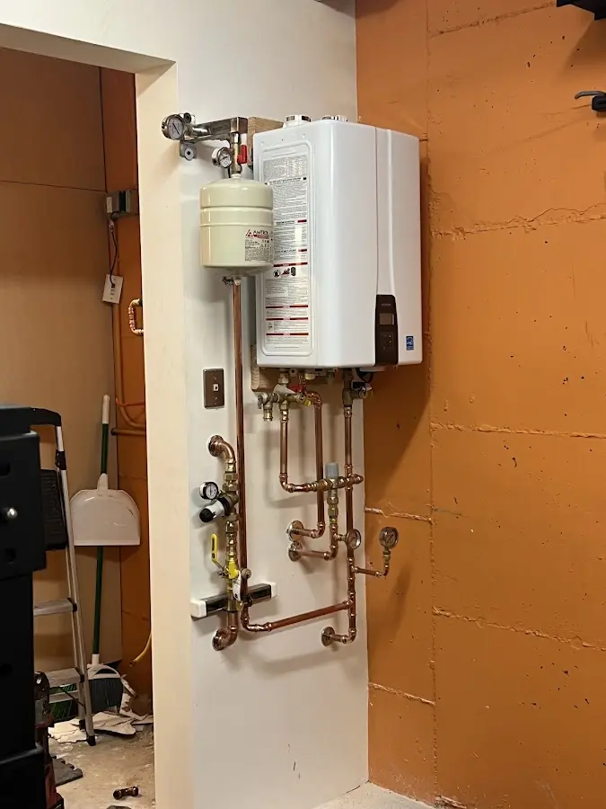 Plumbing technician inspecting water heater connections in Wallace